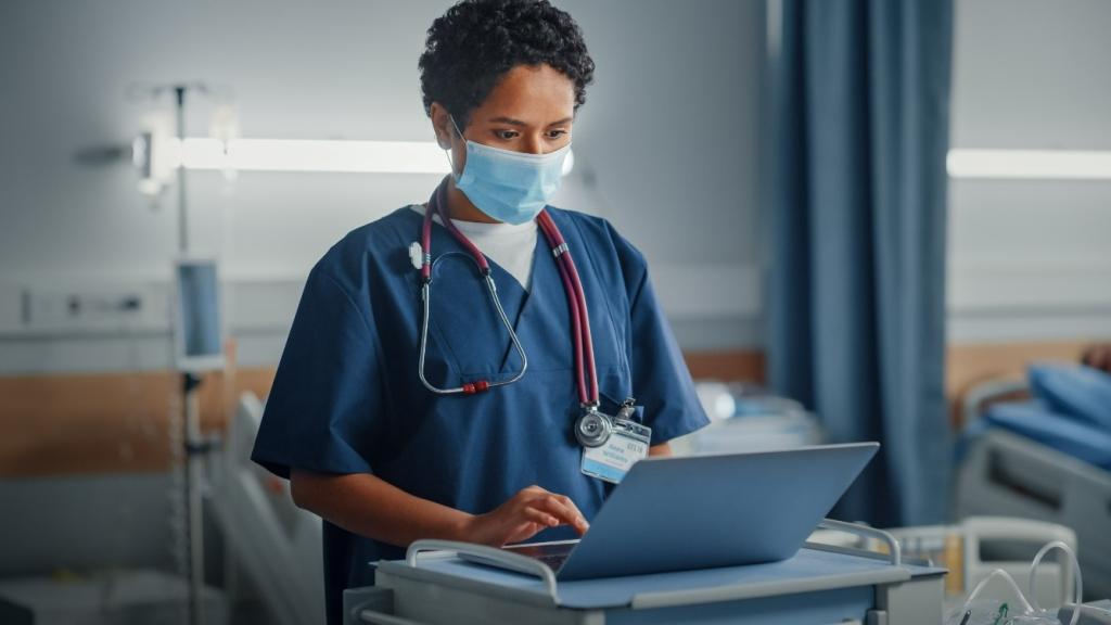 medical worker at a computer on a ward