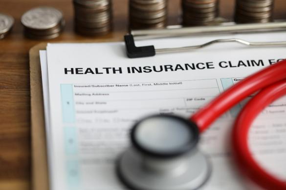 stethoscope on insurance claim on clipboard with money